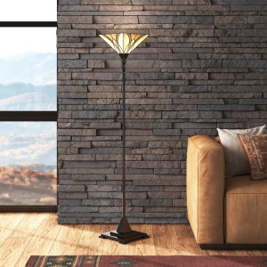 Stained glass floor lamp in front of a stone wall