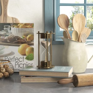 Kitchen counter scene with an hourglass timer, cookbooks, and ladles